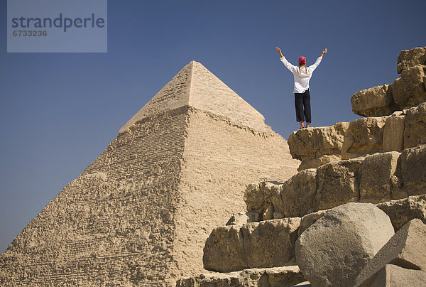 pyramidenförmig  Pyramide  Pyramiden  Kairo  Hauptstadt  hoch  oben  nahe  Frau  heben  Tourist  frontal  Gise