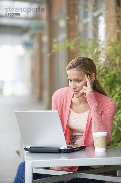 Frau mit Laptop im cafe