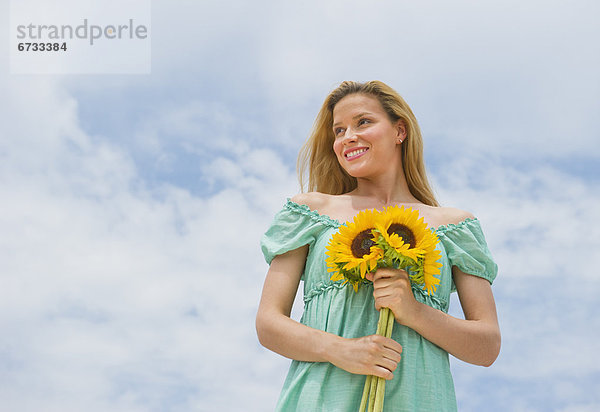 Frau hält Sonnenblumen