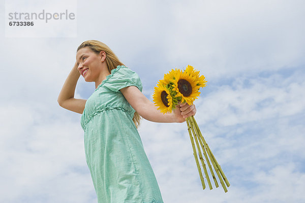 Frau hält Sonnenblumen