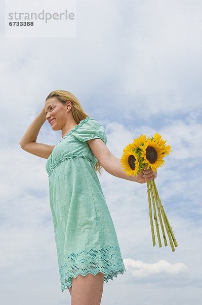 Frau hält Sonnenblumen