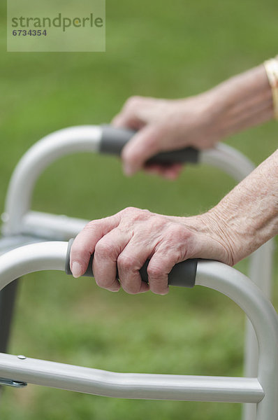 Senior walking with walker  close-up of hands