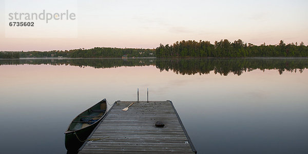 nebeneinander  neben  Seite an Seite  Wasser  Sonnenuntergang  Dock  Kanu