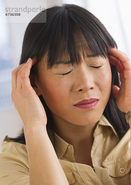 Eine junge Frau mit Kopfschmerzen