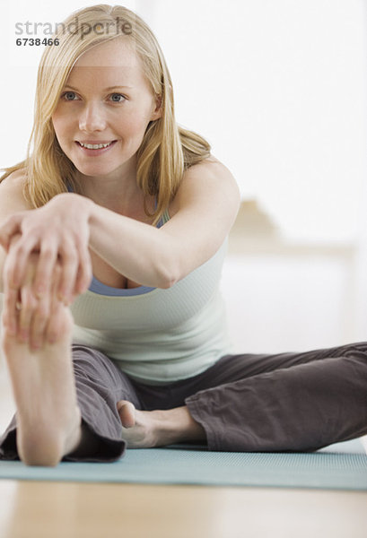 Frau trainiert auf einer Gymnastikmatte