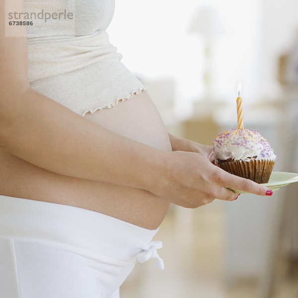 Frau halten Schwangerschaft Kerze cupcake