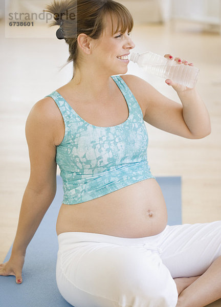 Schwangere trinkt ein Glas Wasser