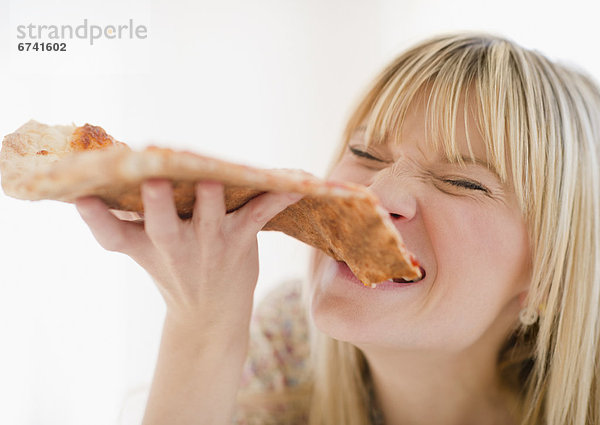 Junge Frau beim Pizza essen