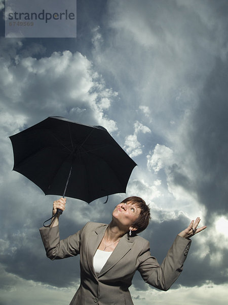 Geschäftsfrau hält einen Regenschirm