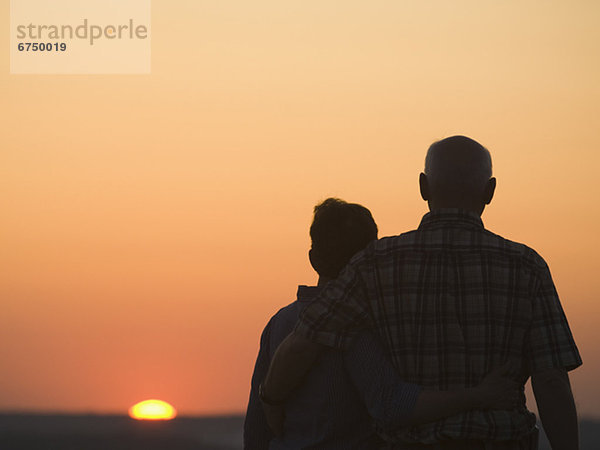 Paar beobachten Sonnenuntergang