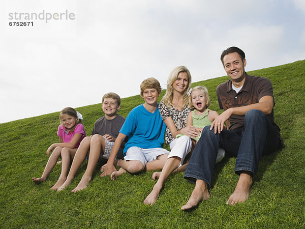 Familie sitzt im Gras