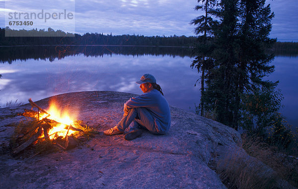 Man Sitting by Campfire  Wanzatika Lake  Northern Ontario
