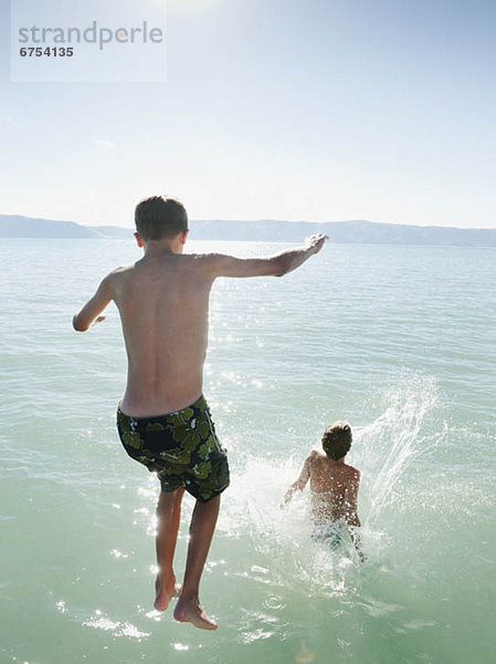 Boys (10-11 12-13) jumping into lake