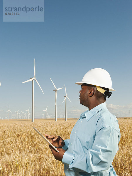 Vereinigte Staaten von Amerika USA Windturbine Windrad Windräder stehend frontal Ingenieur Weizenfeld benutzt Tablet PC