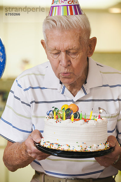 Senior  Senioren  Mann  blasen  bläst  blasend  Geburtstag  Kuchen  Kerze