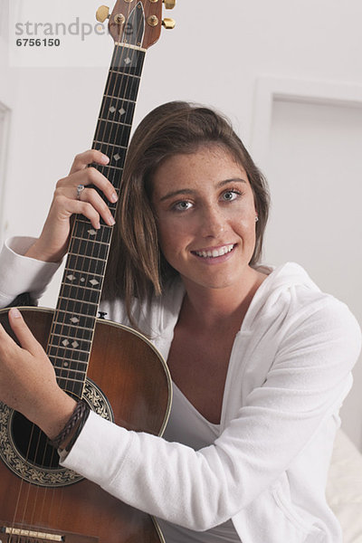 Junge Frau hält Gitarre