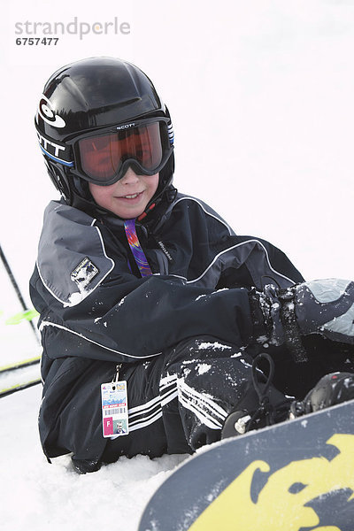 Boy Snowboarder Sitting on Slope  Alberta Rocky Mountains