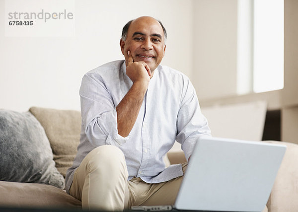 Mann arbeitet auf Laptop