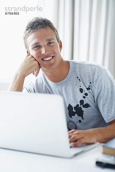 Junger Mann auf Laptop arbeiten