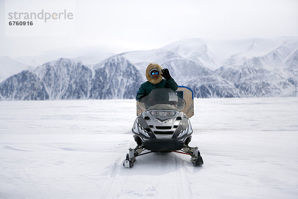 zwischen  inmitten  mitten  Mann  Eis  winken  Insel  Schneemobil  Inuit  Nunavut