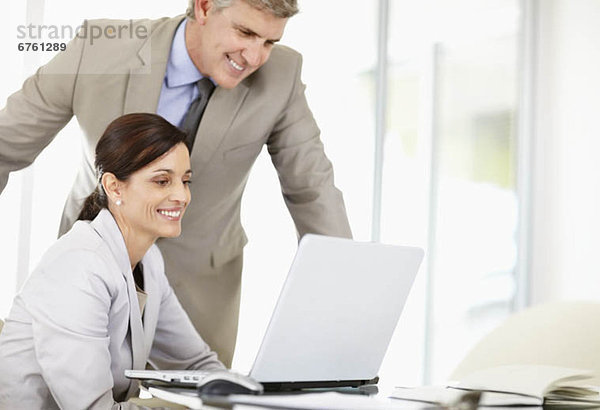 Business associates discussing image displayed on computer screen