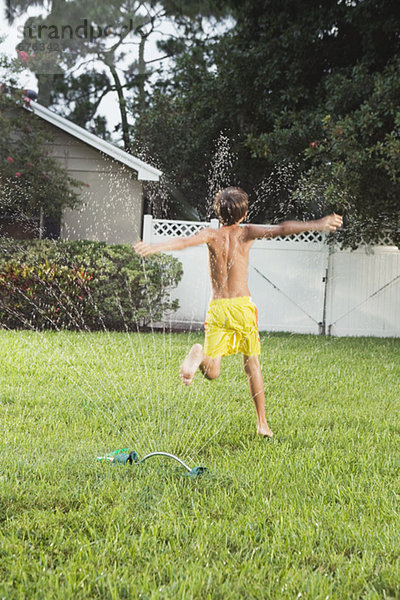 Boy durch Sprinkler