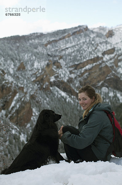 Vereinigte Staaten von Amerika  USA  sitzend  Frau  Hügel  Schnee  Hund  jung  Colorado