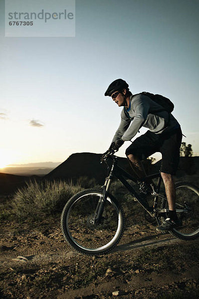 Mann Mountainbike bei Sonnenuntergang