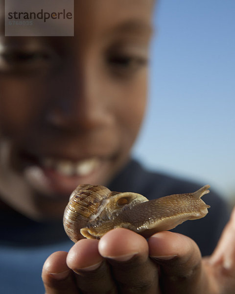 Junge hält Schnecke