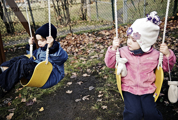 Kälte  schaukeln  schaukelnd  schaukelt  schwingen  schwingt schwingend  Tag  Junge - Person  gelb  Herbst  Mädchen  spielen  Quebec