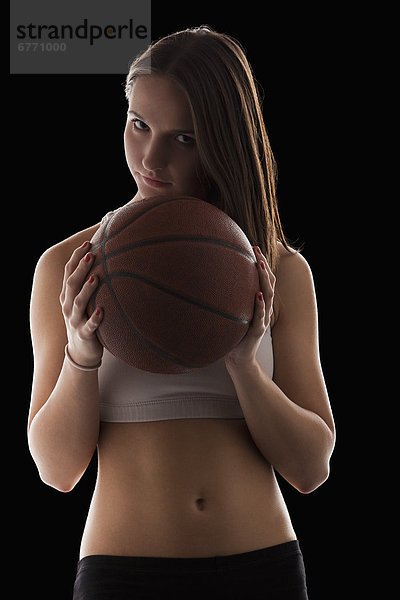 Portrait  Frau  halten  Basketball  jung  Studioaufnahme