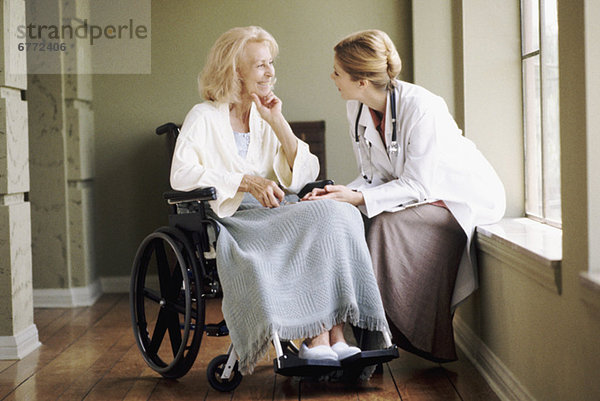Frau  sprechen  Arzt  Rollstuhl