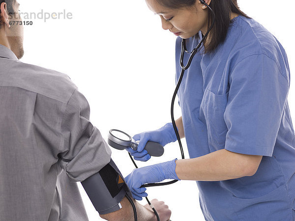 Krankenschwester überprüfen Patienten Blutdruck