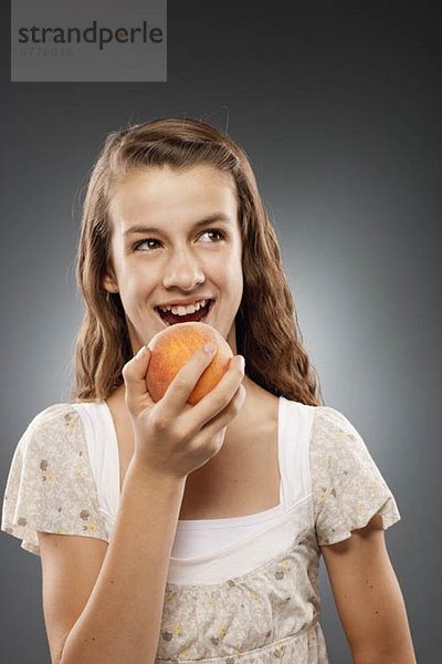 Studioaufnahme  lachen  halten  Pfirsich  12-13 Jahre  12 bis 13 Jahre  Mädchen
