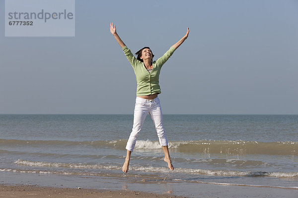 Springende Frau am Strand