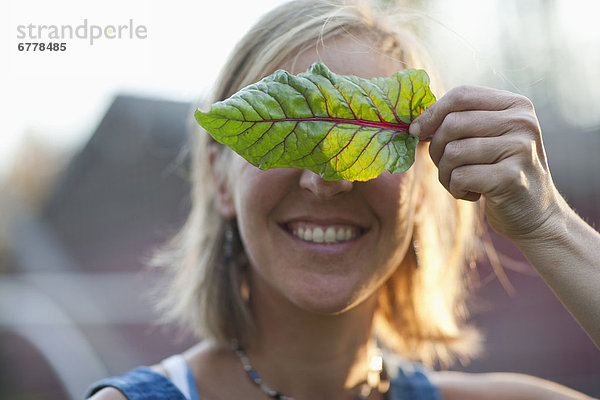 Frau  lächeln  Pflanzenblatt  Pflanzenblätter  Blatt  halten  frontal