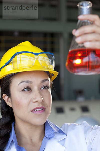 Laborant  Bauarbeiterhelm  Frau  sehen  Meßbecher  flüssig  Mantel  rot  Kleidung