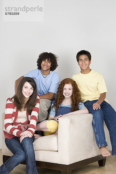 Portrait of teenagers (14-15 16-17) sitting on armchair