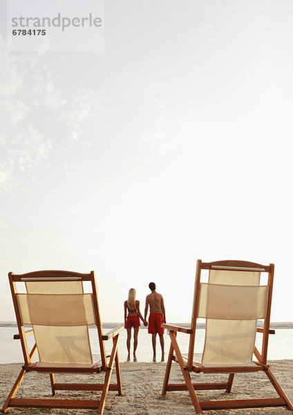 Junge Paar hält Hände am Strand