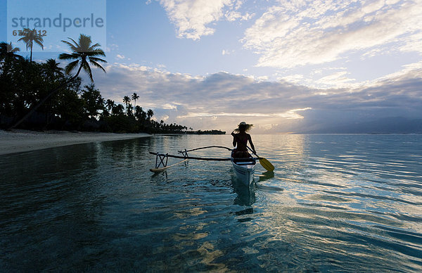 Französisch-Polynesien  Moorea  Frau Paddeln in Auslegerkanu entlang Küste.