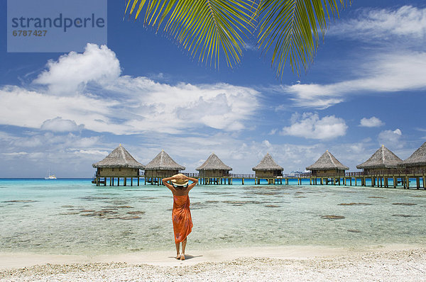 Französisch-Polynesien  Tuamotu-Inseln Rangiroa Atoll  Frau am Strand in der Nähe von Luxus-Resort.