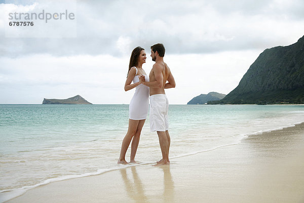 Hawaii  Oahu  Waimanalo  Young glückliches Paar hält einander am Strand