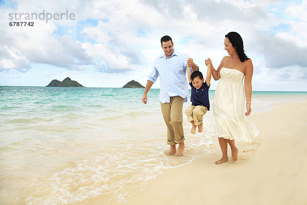 Hawaii  Oahu  Lanikai  junge Familie hält hände Spaziergang am Strand entlang.