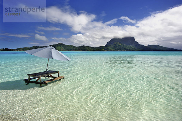 Französisch-Polynesien  Tahiti  Bora Bora  Picknick-Tisch und Regenschirm in clear Lagoon Wasser.