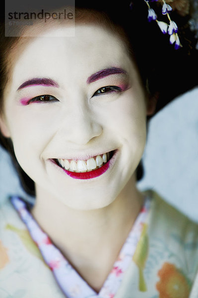 Portrait der japanischen Maiko mit breiten Lächeln.