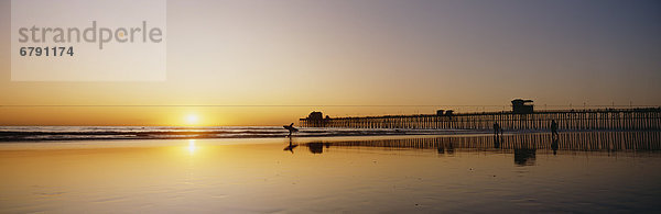 Kalifornien  Oceanside Pier und Surfer silhouetted gegen Sonnenuntergang  Überlegungen zum Strand.