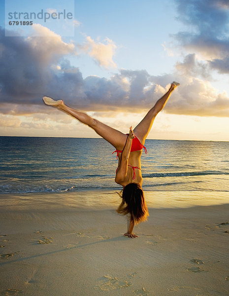 Hawaii  Oahu  Mädchen am Strand im Badeanzug Gymnastik zu tun.