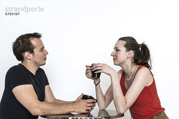 Paar sitzt an einem Tisch und unterhält sich  trinkt Kaffee