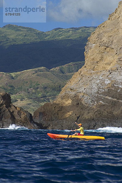 Hawaii  Molokai  kayaker exploring Moku Ho'oniki Islet.