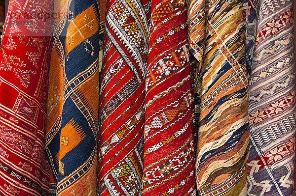 Bunte Webteppiche mit traditionellen Mustern der Araber und Berber sind im Souk oder Basar zum Verkauf ausgehängt  Marrakesch  Marokko  Afrika